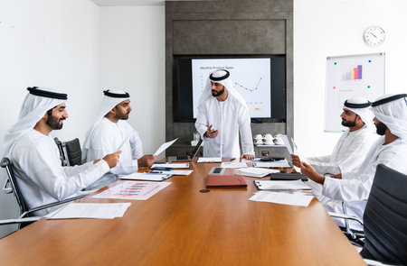 Arab businessmen wearing emirati kandura meeting in office for business deal - Corporate business group of middle-eastern people working in an international company in middle eastの写真素材