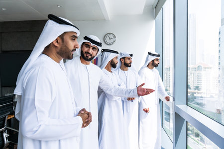 Arab businessmen wearing emirati kandura meeting in office for business deal - Corporate business group of middle-eastern people working in an international company in middle eastの写真素材