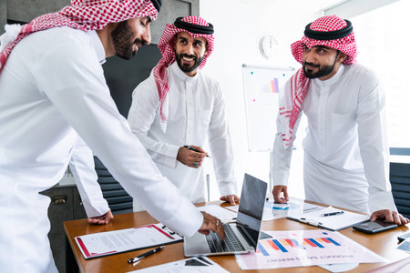 Arab businessmen wearing saudi kandura meeting in office for business deal - Corporate business group of middle-eastern people working in an international company in middle eastの写真素材