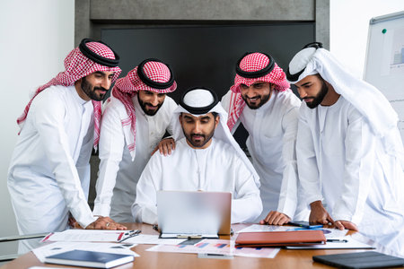 Arab businessmen wearing emirati and saudi kandura meeting in office for business deal - Corporate business group of middle-eastern people working in an international company in middle eastの写真素材