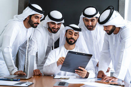 Arab businessmen wearing emirati kandura meeting in office for business deal - Corporate business group of middle-eastern people working in an international company in middle eastの写真素材