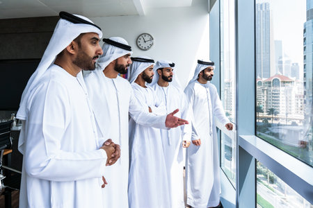 Arab businessmen wearing emirati kandura meeting in office for business deal - Corporate business group of middle-eastern people working in an international company in middle eastの写真素材
