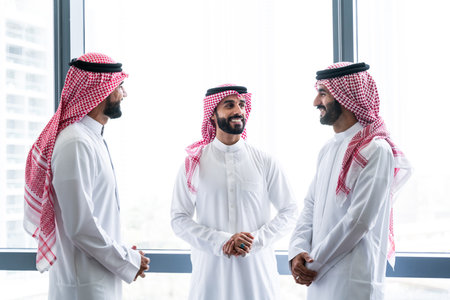 Arab businessmen wearing saudi kandura meeting in office for business deal - Corporate business group of middle-eastern people working in an international company in middle eastの写真素材