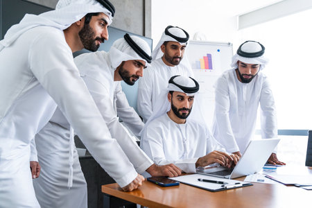 Arab businessmen wearing emirati kandura meeting in office for business deal - Corporate business group of middle-eastern people working in an international company in middle eastの写真素材