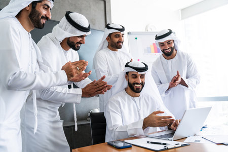 Arab businessmen wearing emirati kandura meeting in office for business deal - Corporate business group of middle-eastern people working in an international company in middle eastの写真素材