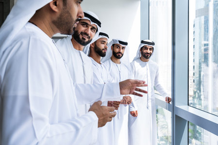 Arab businessmen wearing emirati kandura meeting in office for business deal - Corporate business group of middle-eastern people working in an international company in middle eastの写真素材