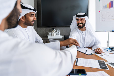 Arab businessmen wearing emirati kandura meeting in office for business deal - Corporate business group of middle-eastern people working in an international company in middle eastの写真素材