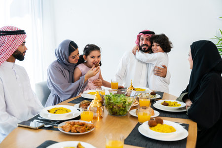 Happy arab family wearing saudi arabia clothing spending time together at home during dinner -...