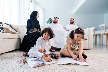 Happy arab family wearing emirati clothing spending time together at home - Middle-eastern parents and children bonding in modern apartment in Dubaiの写真素材