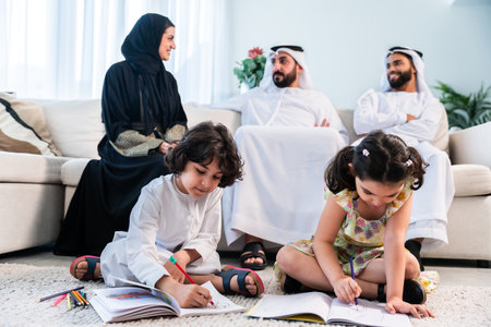 Happy arab family wearing emirati clothing spending time together at home - Middle-eastern parents and children bonding in modern apartment in Dubaiの写真素材