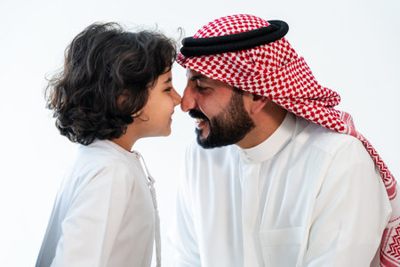 Happy arab family wearing saudi arabia clothing spending time together at home - Middle-eastern saudi parents and children playing, concepts about parenthood and middle eastern lifestyleの写真素材