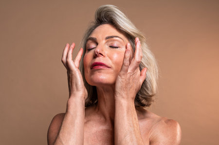 Beauty portrait of beautiful mature woman, concepts about cosmetics, skincare and wellness. Mature woman enjoying a skincare routineの写真素材
