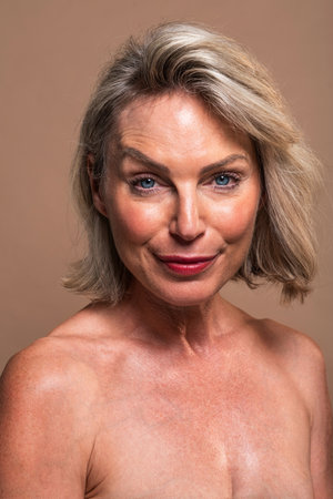 Beauty portrait of beautiful mature woman, concepts about cosmetics, skincare and wellness. Studio portrait of a confident mature woman with bare shoulders. Radiating charm and showing healthyの写真素材