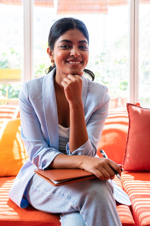 Beautiful indian business woman working in a coworking corporate company office - Young female wearing business casual clothing works in a creative startup tech company, concepts about business and daily office lifestyleの写真素材
