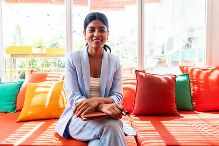 Beautiful indian business woman working in a coworking corporate company office - Young female wearing business casual clothing works in a creative startup tech company, concepts about business and daily office lifestyleの写真素材