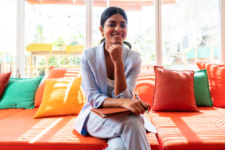 Beautiful indian business woman working in a coworking corporate company office - Young female wearing business casual clothing works in a creative startup tech company, concepts about business and daily office lifestyleの写真素材