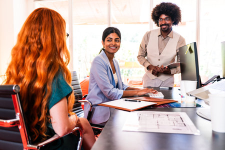 Multiethnic small group of businesspeople meeting in a coworking corporate company office - Young coworkers colleagues working together in a creative startup tech company, concepts about business and daily office lifestyleの写真素材