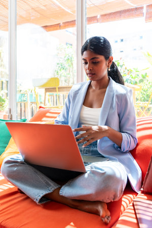 Beautiful indian business woman working in a coworking corporate company office - Young female wearing business casual clothing works in a creative startup tech company, concepts about business and daily office lifestyleの写真素材