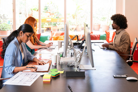 Multiethnic small group of businesspeople meeting in a coworking corporate company office - Young coworkers colleagues working together in a creative startup tech company, concepts about business and daily office lifestyleの写真素材