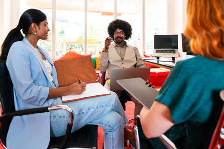 Multiethnic small group of businesspeople meeting in a coworking corporate company office - Young coworkers colleagues working together in a creative startup tech company, concepts about business and daily office lifestyleの写真素材