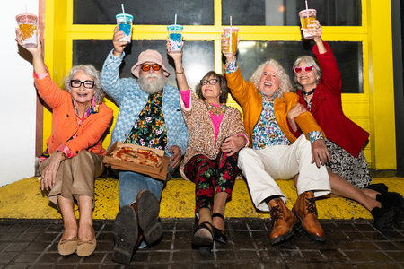 Group of happy senior friends with fancy clothing having party in the night on city streets -...