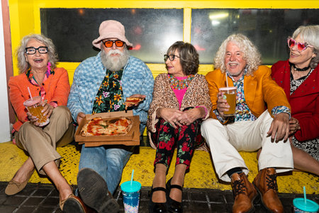 Group of happy senior friends with fancy clothing having party in the night on city streets - Cheerful elderly people wearing fashionable clothes celebrating and having fun outdoorsの写真素材