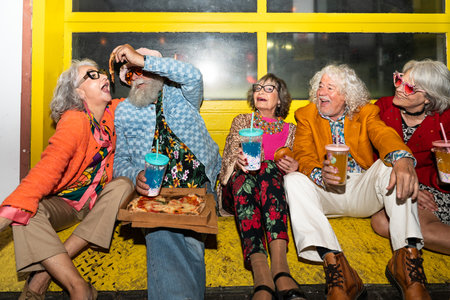 Group of happy senior friends with fancy clothing having party in the night on city streets -...