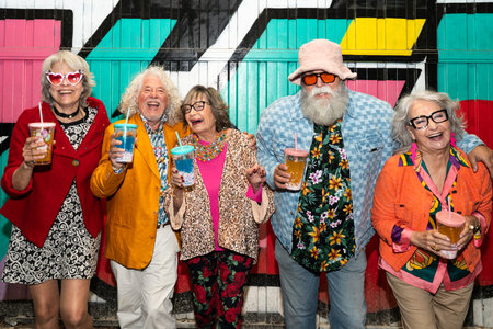 Group of happy senior friends with fancy clothing having party in the night on city streets - Cheerful elderly people wearing fashionable clothes celebrating and having fun outdoorsの写真素材