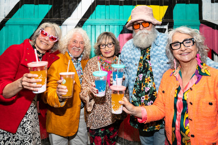 Group of happy senior friends with fancy clothing having party in the night on city streets -...