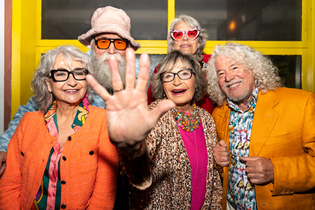 Group of happy senior friends with fancy clothing having party in the night on city streets -...
