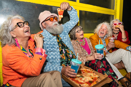 Group of happy senior friends with fancy clothing having party in the night on city streets - Cheerful elderly people wearing fashionable clothes celebrating and having fun outdoorsの写真素材