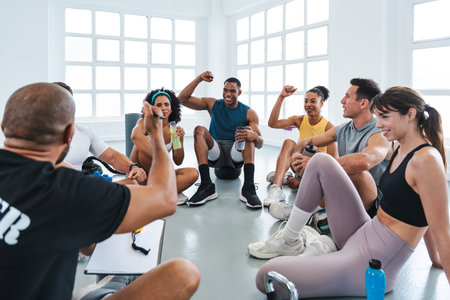 Multiethnic group of sportive people doing functional workout in training class gym group of athletes sitting in a circle on the gym floor