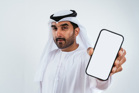 Middle-eastern doctor wearing kandura working in the office - businessman in traditional kandura...
