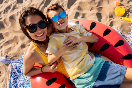 Happy beautiful asian family having fun at the beach during summertime vacation - Chinese mother and mixed race asian children spending time together at the sea, concepts about family, motherhood and diversityの写真素材