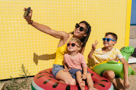 Happy beautiful family having fun at the beach during summertime vacation - Chinese mother and mixed...
