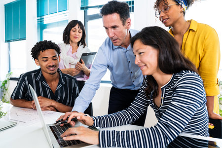 Business team collaborating on a laptop, analyzing data and strategizing during a productive office...