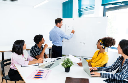 Diverse business professionals collaborating in a modern office during a productive meeting, with a...