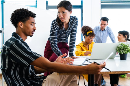 Diverse team of professionals working together, analyzing data, and discussing strategies during a...