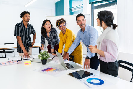Business colleagues are working together, analyzing graphs and charts on a laptop during a...