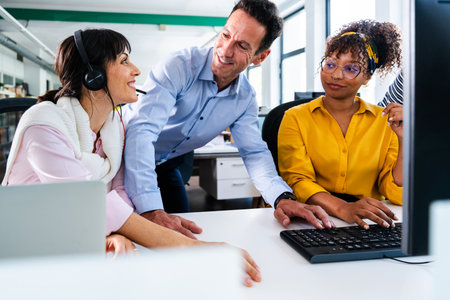 Business colleagues are working together on a computer, discussing a project in a modern office...