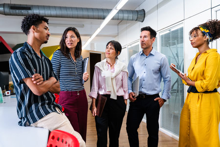 Diverse team of business professionals collaborating and discussing startup strategy during a...