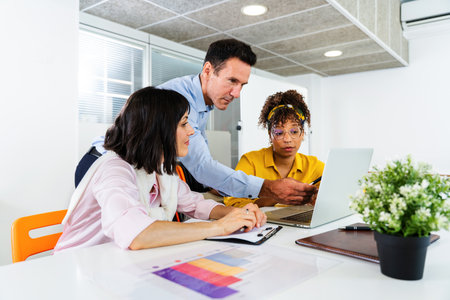 Business team collaborating on a project, analyzing data on a laptop and discussing strategies in a...