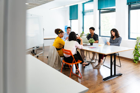 Diverse teams of professionals are having a productive meeting in a contemporary office space,...