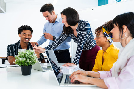 Business colleagues collaborating around a table in a modern startup office, sharing ideas and...