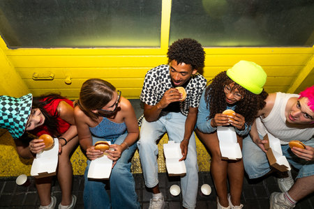 Multiethnic group of young friends having fun on the streets in the night - Stylish cool multiracial people wearing stylish clothing hanging out before partyの写真素材