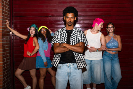 Multiethnic group of young friends having fun on the streets in the night - Stylish cool multiracial people wearing stylish clothing hanging out before party in a nightclubの写真素材