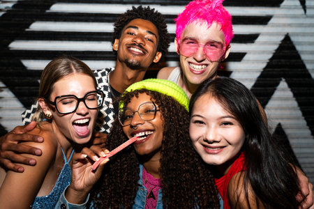 Multiethnic group of young friends having fun on the streets in the night - Stylish cool multiracial...