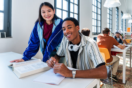 Multiethnic group of young students meeting at the library - young diverse students collaborating on...