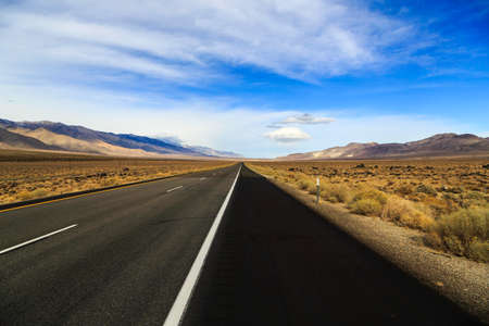 Converging Freeway through Mountains and Barren Landの写真素材