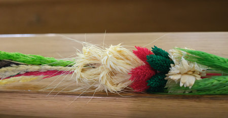 A close-up shot reveals an arrangement featuring various colors including beige, green, red, and white, and rests on a light brown wooden surface.の写真素材